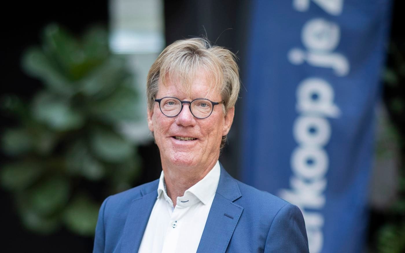 Portret van Bernd, staand bij een Verkoop je Zaak-banner