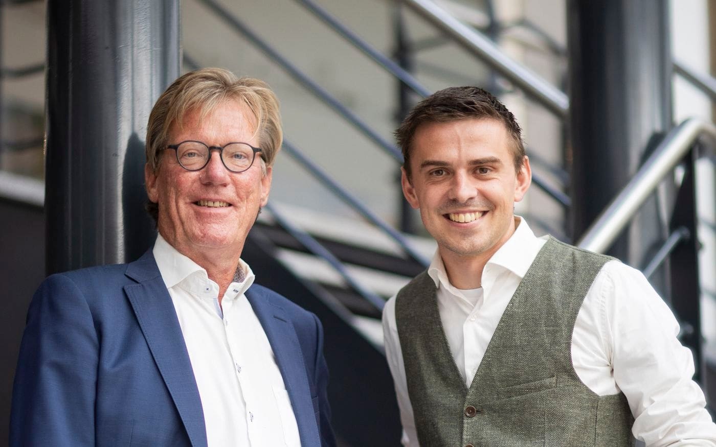 Maarten Ligthart en Bernd samen op de trap, adviesduo bij bedrijfsovername