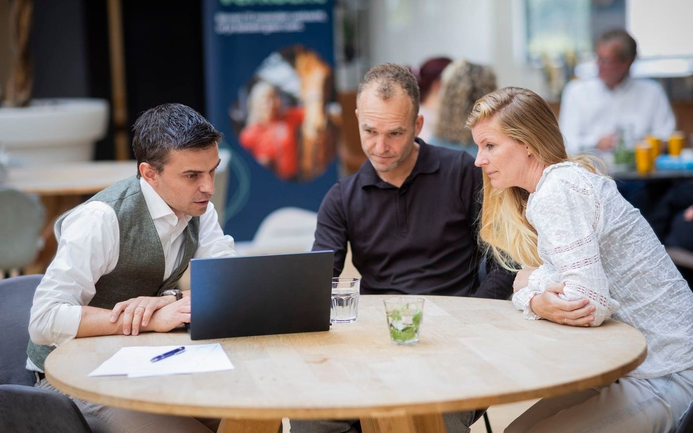 Overleg achter de laptop tussen ondernemer en adviseurs