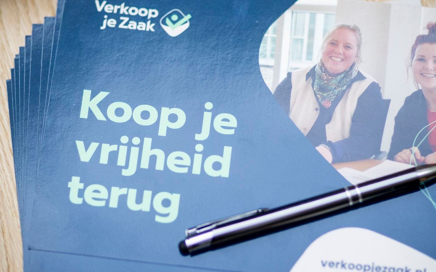 Het boek Built to Sell naast materiaal van Verkoop je Zaak op tafel