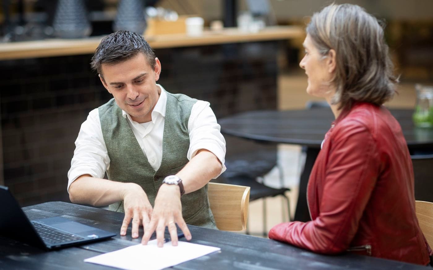 Adviseur en koper bespreken de voorwaarden aan de onderhandeltafel