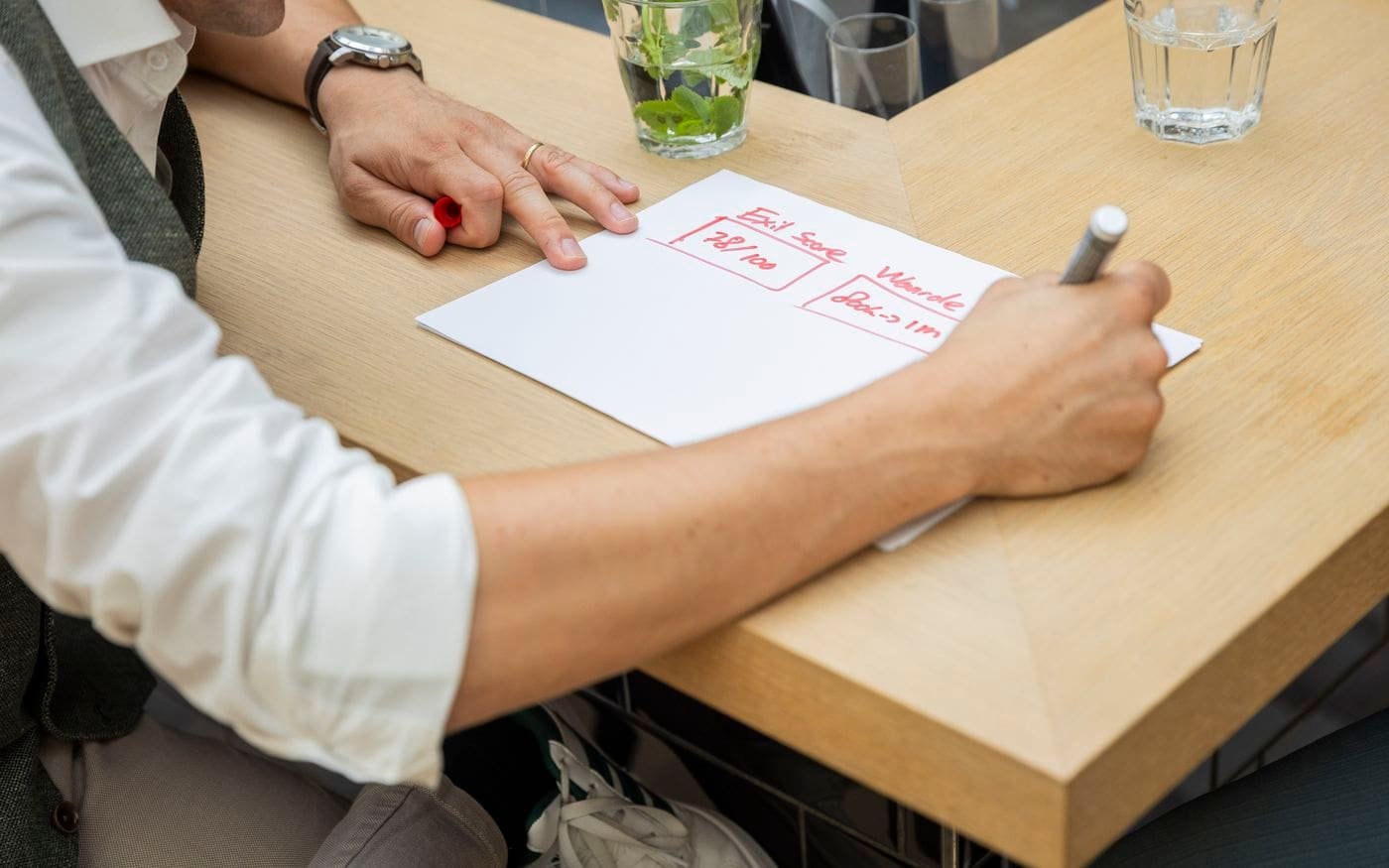 Aantekeningen met een rode pen op papier tijdens een adviesgesprek