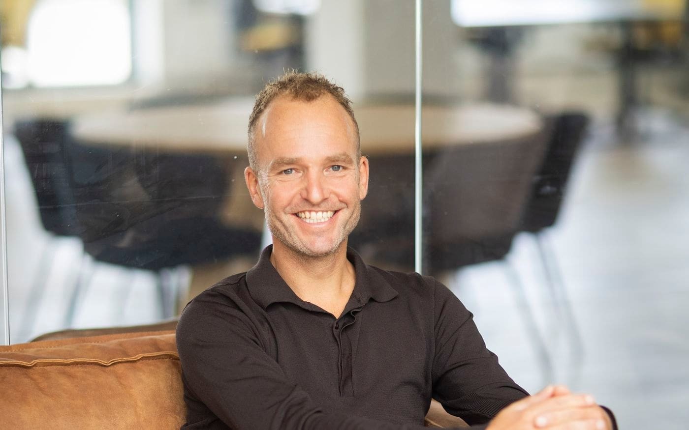 Ondernemer zit ontspannen op een leren bank na de verkoop