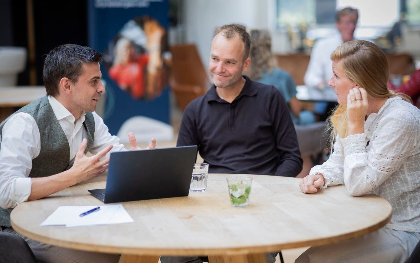 Ondernemer en adviseurs nemen achter de laptop de stukken door