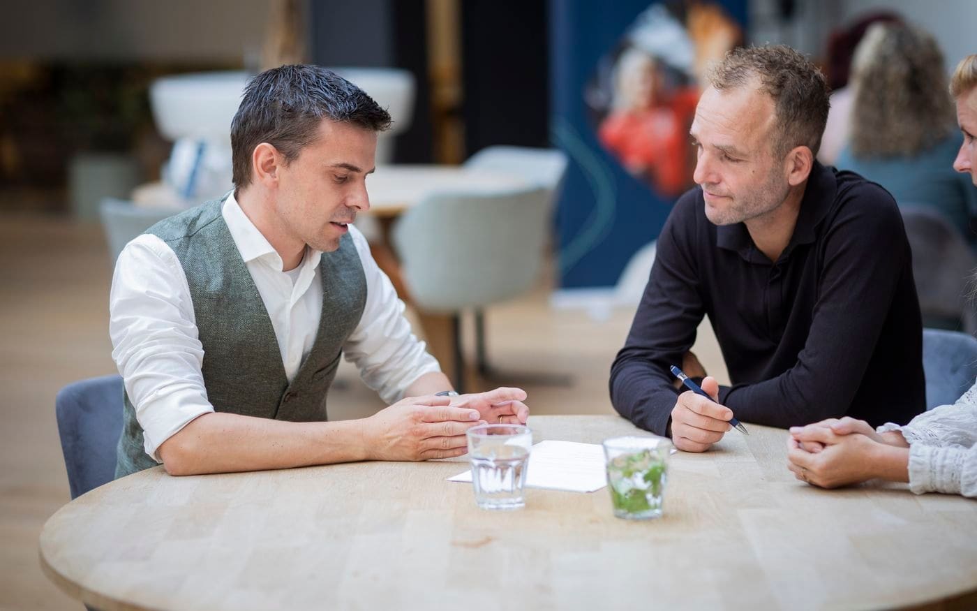 Twee gesprekspartners tegenover elkaar aan tafel