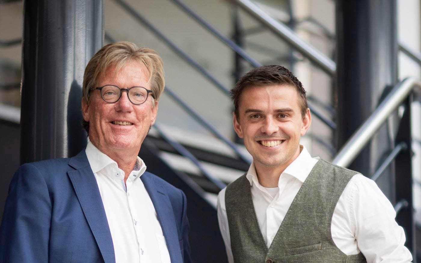 Maarten Ligthart en Bernd lachend naast elkaar, werkend op no cure no pay
