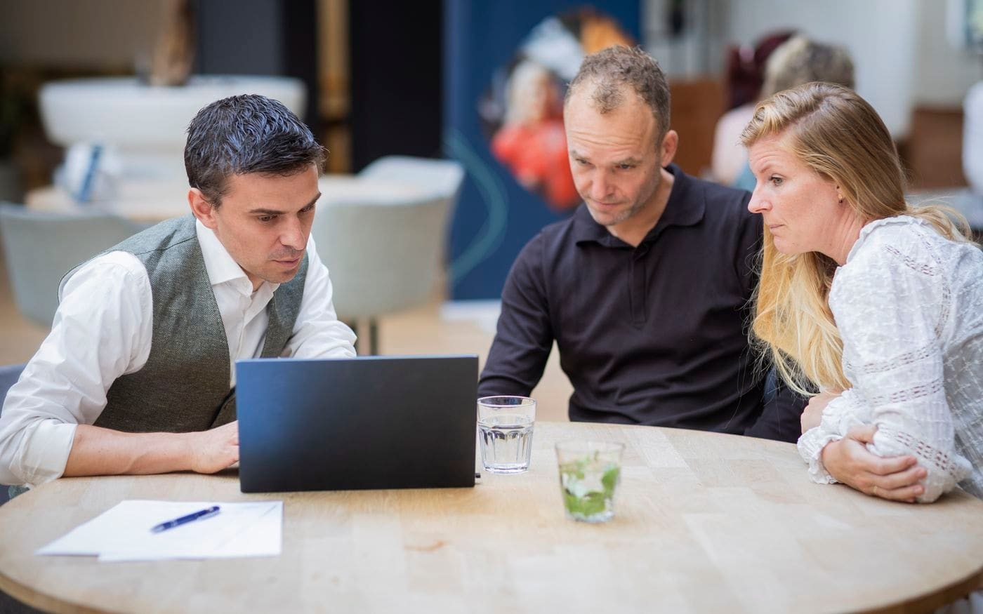 Ondernemer en adviseurs bespreken cijfers achter de laptop