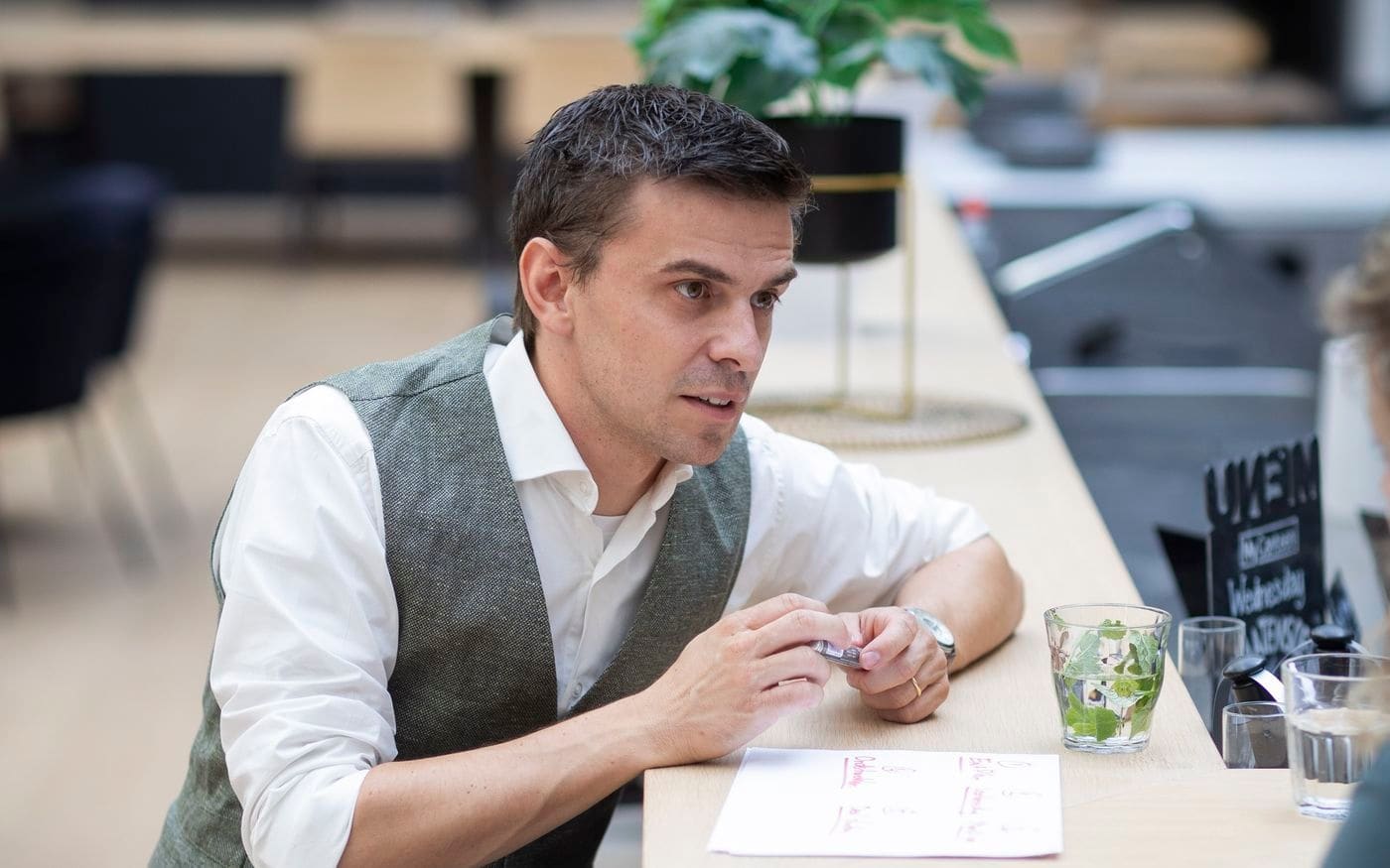 Adviseur werkt iets uit op papier aan de hoge tafel