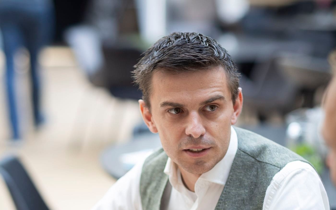 Adviseur gebaart tijdens de uitleg aan de overkant van de tafel