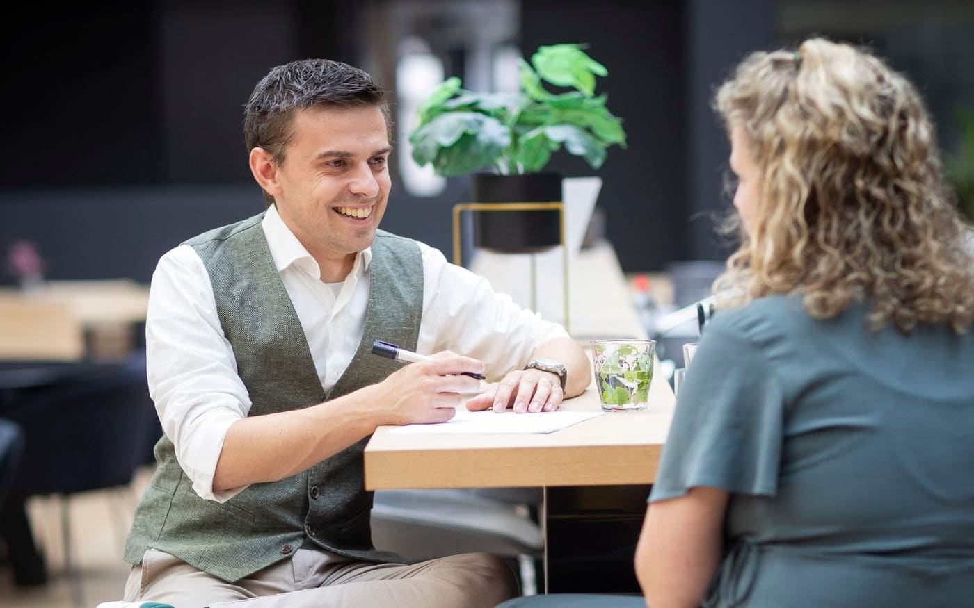 Adviseur in gesprek met een onderneemster aan de hoge tafel