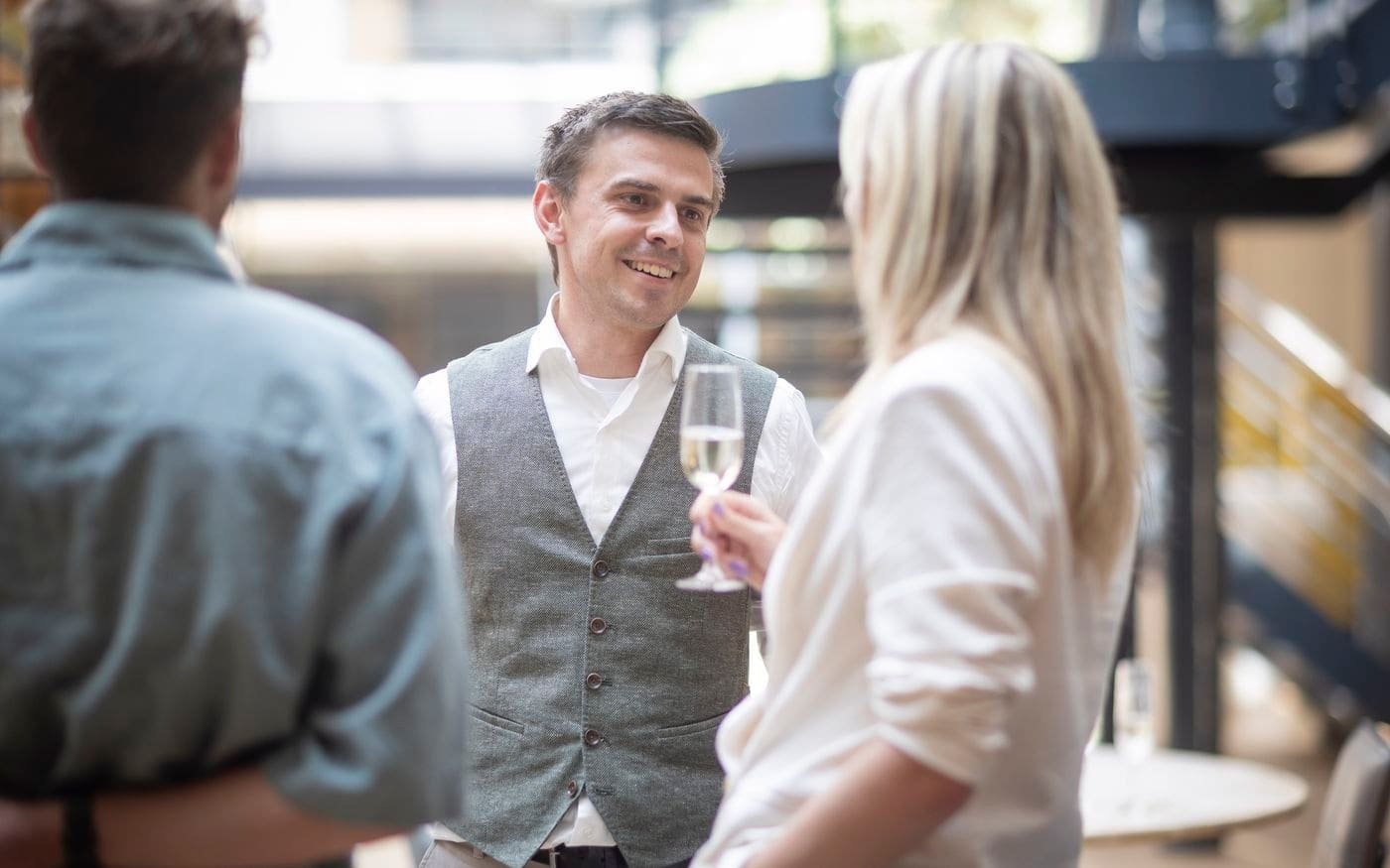 Ondernemer proost lachend met een glas champagne