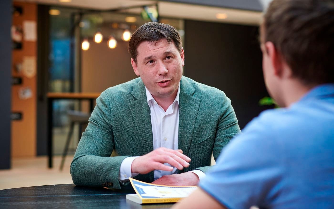 Man in gesprek aan de overkant van de tafel