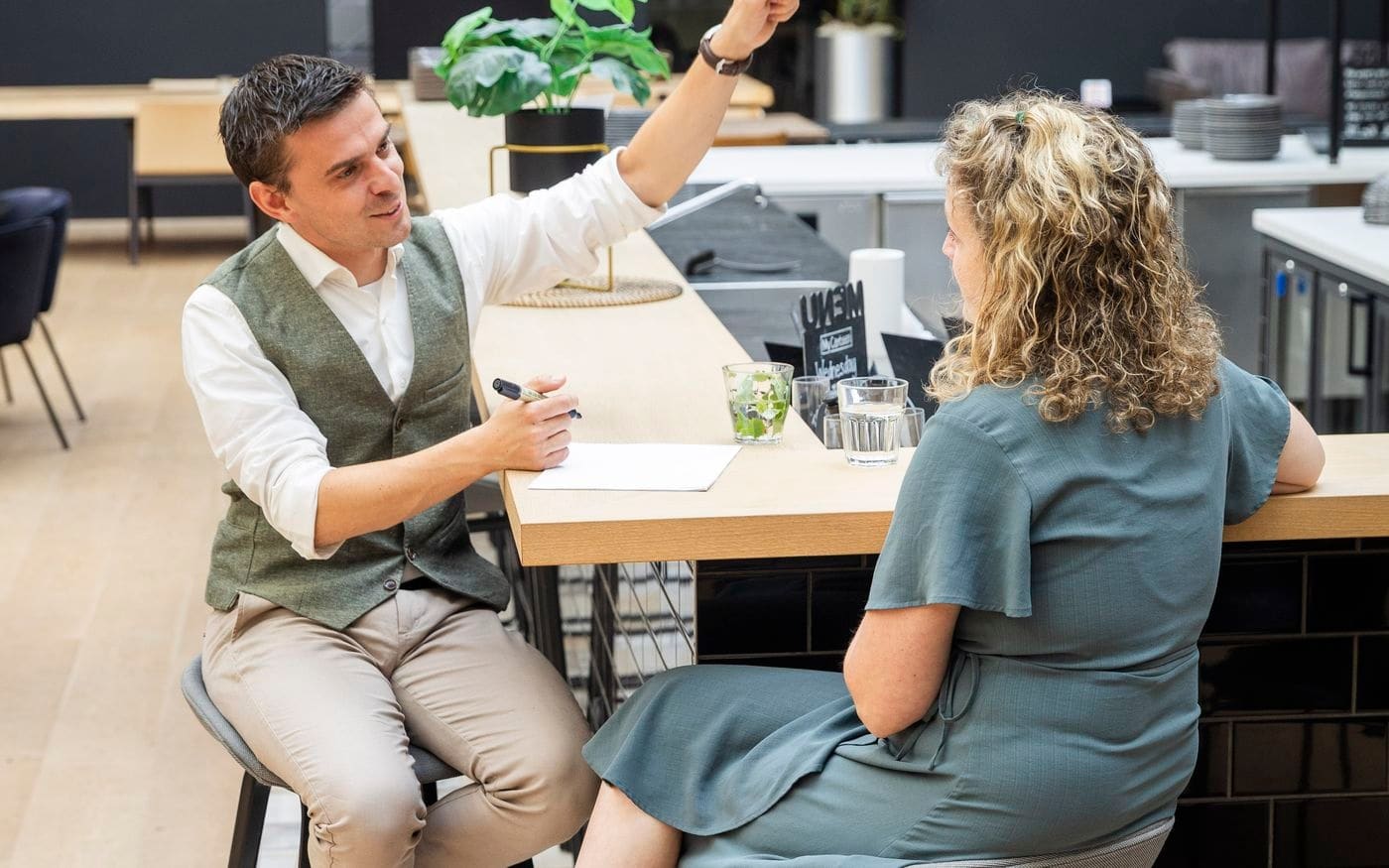 Ondernemer en adviseur in gesprek aan een hoge tafel