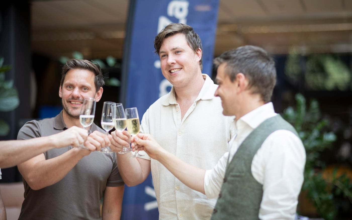 Ondernemers klinken met champagneglazen na de verkoop