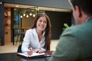 Bedrijfsmakelaar in gesprek met ondernemer over de verkoop van een bedrijf